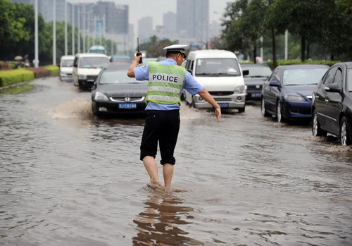 A policeman directs traffic in a flooded street after heavy rains brought by tropical storm Meranti in Hangzhou, East China&apos;s Zhejiang province, Sept 12, 2010. [Xinhua]