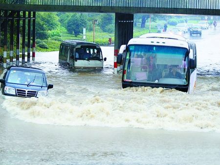 Some vehicles are trapped by flood under a bridge in Hangzhou, Zhejiang Province, on September 12. Tropical storm Meranti hit the province yesterday and triggered landslides, a debris flow and delayed flights. 