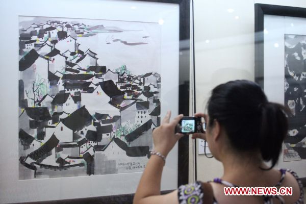 A visitor takes photo at the exhibition in honour of late Chinese artist Wu Guanzhong held in his hometown Yixing City, east China's Jiangsu Province, Sept. 12, 2010. The exhibition displayed 30 pieces of works of Wu, a master of Chinese paintings.
