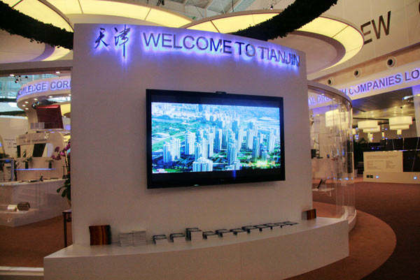 An LCD screen shows a promotional video for Tianjin.