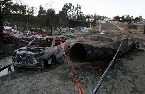 A burned out automobile is shown next to a ruptured gas line amid rubble after a fire caused by a gas pipeline explosion in a neighborhood in San Bruno, California September 10, 2010. [China Daily/Agencies]