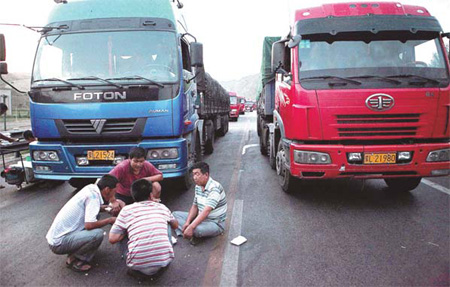 Stranded drivers play cards to kill time while waiting in the giant traffic jam on the Beijing-Tibet Expressway on Aug 16. The congestion was caused by construction work on the route. 