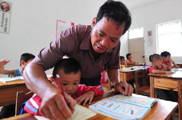 Shi teaches a student to write Chinese characters in South China's Guangxi Zhuang autonomous region on Sept 6, 2010. 