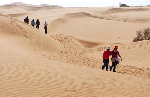 With help from volunteers, a group of visually impaired people go hiking in the desert in northwest China&apos;s Ningxia Hui autonomous region on Sept 13, 2010. [Xinhua]