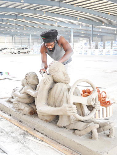 A Zambian artist works on his piece for the international sculpture exposition in Changchun, Northeast China&apos;s Jilin province, Sept 13, 2010. A total of 29 artists from 26 countries are taking part in the automobile-themed expo in Changchun. The event also received 1,059 art pieces from 340 artists worldwide, of which 31 pieces will be permanently on display at the city&apos;s automobile park. [Xinhua]