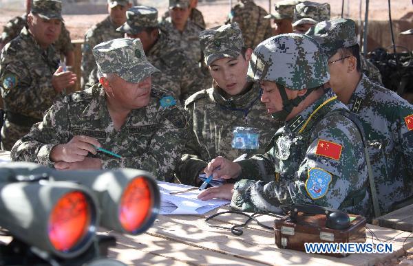 Officers of China and Kazakhstan discuss training plan during the joint military training of troops from five Shanghai Cooperation Organization member states in Matybulak Range in Kazakhstan, Sept. 14, 2010. As part of the &apos;Peace Mission 2010&apos; joint anti-terror drills, soldiers and military officers from Kazakhstan, China, Kyrgyzstan, Russia and Tajikistan conducted the joint military training in Kazakhstan on Tuesday.[Xinhua]