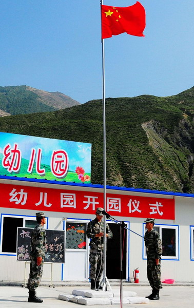 A flag raising ceremony is held during the opening of a newly-built kindergarten for victims of mudslide-hit Zhouqu in Gansu province on September 14, 2010. [Photo/Xinhua] 