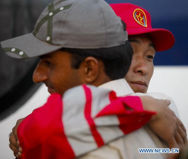 Members of China's first and second group of aid workers share a sensational moment during the handover ceremony in Thatta of Pakistan, Sept. 14, 2010. The second Chinese aid team, consisting of 59 members, arrived in Thatta region, which was the worst-hit area in Pakistan's recent nationwide flood, on Tuesday to continue the humanitarian mission. [Zhou Lei/Xinhua]