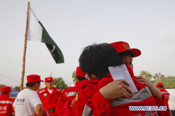 Members of China's first and second group of aid workers share a sensational moment during the handover ceremony in Thatta of Pakistan, Sept. 14, 2010. The second Chinese aid team, consisting of 59 members, arrived in Thatta region, which was the worst-hit area in Pakistan's recent nationwide flood, on Tuesday to continue the humanitarian mission. [Zhou Lei/Xinhua]