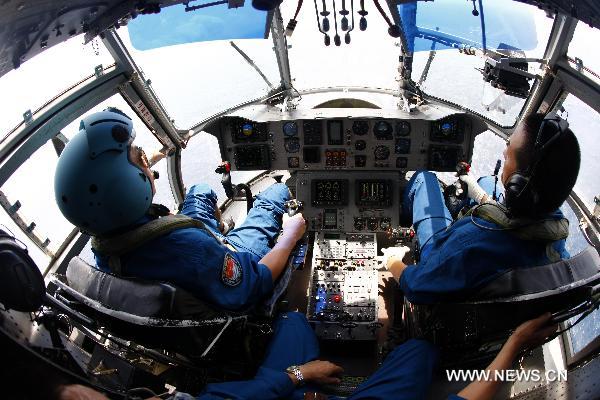 Two Chinese soldiers polite a new model of rescue medical helicopter during an exercise in the sea area of Indian Ocean, Sept. 14, 2010. The helicopter made its first debut on Monday after successfully accomplishing the landfall task on the board of hospital ship Peace Ark of the Navy of the Chinese People's Liberation Army. [Xinhua photo]