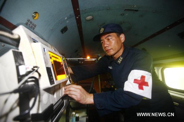 Liu Bingli, head of a medical team on a new model of rescue medical helicopter, participates in an exercise in the sea area of Indian Ocean, Sept. 14, 2010. The helicopter made its first debut on Monday after successfully accomplishing the landfall task on the board of hospital ship Peace Ark of the Navy of the Chinese People's Liberation Army. [Xinhua photo]