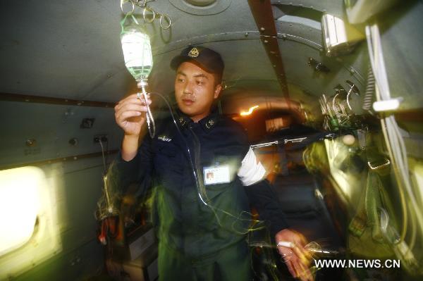 Li Jianguo, a member of a medical team on a new model of rescue medical helicopter, participates in an exercise in the sea area of Indian Ocean, Sept. 14, 2010. The helicopter made its first debut on Monday after successfully accomplishing the landfall task on the board of hospital ship Peace Ark of the Navy of the Chinese People's Liberation Army. [Xinhua photo]