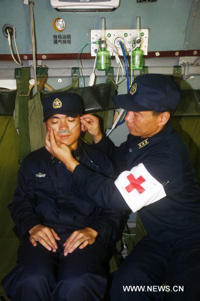 Liu Bingli (R), head of a medical team on a new model of rescue medical helicopter, participates in an exercise in the sea area of Indian Ocean, Sept. 14, 2010. The helicopter made its first debut on Monday after successfully accomplishing the landfall task on the board of hospital ship Peace Ark of the Navy of the Chinese People's Liberation Army. [Xinhua photo]