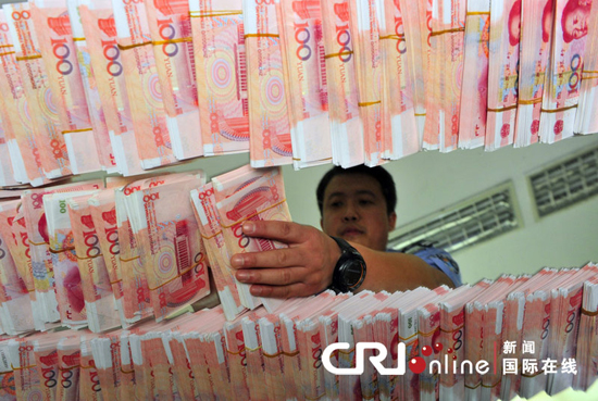 A police officer inspects counterfeit renminbi seized during an operation in Xi’an, Shaanxi Province, Sept .14, 2010.