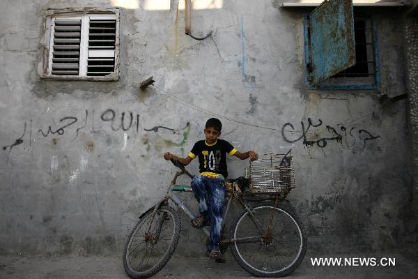 A Palestinian boy sits on a bike near his home in Deir al-Balah refugee camp, central Gaza Strip, on Sept. 15, 2010. [Xinhua]