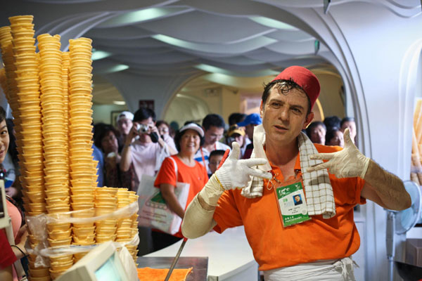 A worker at the Turkey Pavilion at the Shanghai Expo performs for the customers waiting for Turkish ice cream on Thursday. [Xinhua]