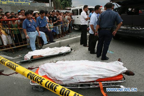 Two bodies of policemen are seen in Quezon City, the Philippines, Sept. 16, 2010. Two policemen were shot dead during an ambush with armed gunmen along Congressional Road in Quezon Thursday. [Xinhua]