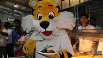 Shera, the mascot of the Commonwealth Games, has lunch with the visiting media at the opening of the Commonwealth Games village in New Delhi, capital of India, Sept. 16, 2010.