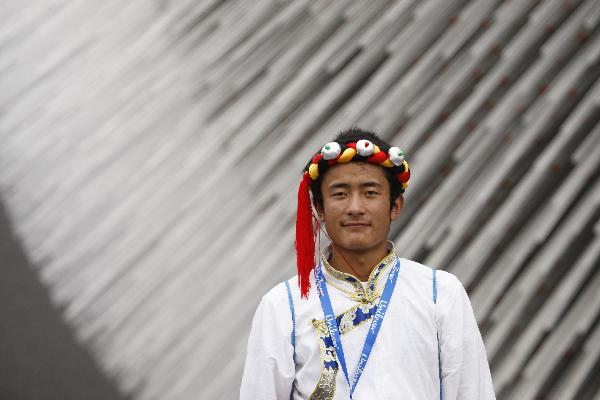 A student from quake-hit Yushu County of northwest China's Qinghai Province poses for a photo in front of the Britain Pavilion at the World Expo Park in Shanghai, east China, Sept. 15, 2010. A total of 30 students of two hope schools in quake-hit Yushu County were invited by Unilever Co. to visit the 2010 World Expo on Wednesday.