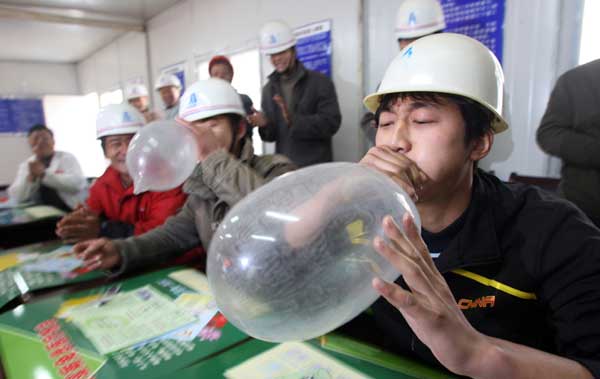 Two migrant workers blow up condoms in a contest that aims to teach them about safe sex and contraception in Hefei, Anhui province, in this file photo. 