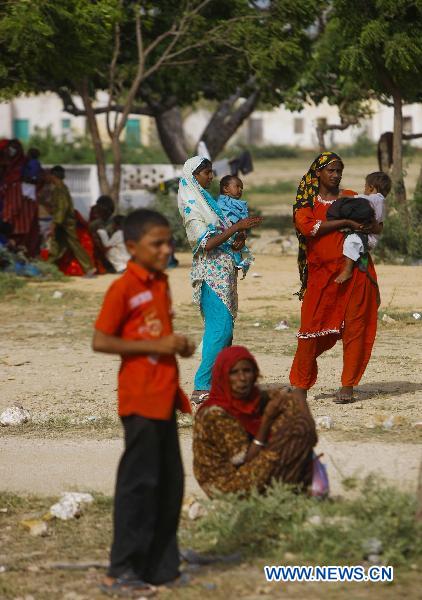 Locals wait for medical treatments at the temporary hospital established by the second Chinese rescue team in Makly town in flood-hit Thatta in southern Pakistan, Sept. 16, 2010. [Zhou Lei/Xinhua]