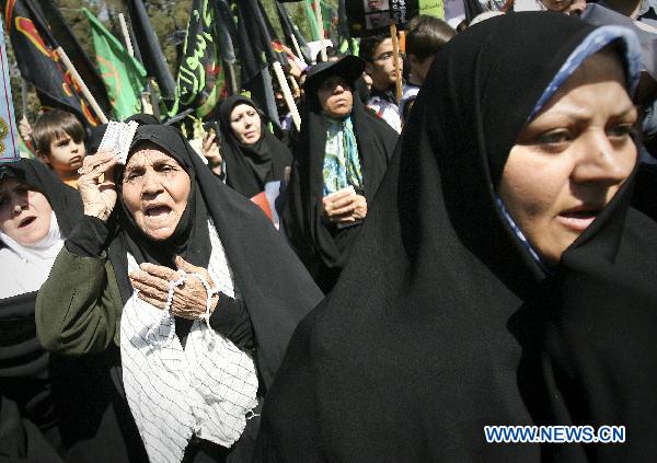 Iranians attend a protest against the threat by a U.S. pastor to burn the Muslim holy book, the Koran, after Friday prayer in Tehran, capital of Iran, on Sept. 17, 2010.[Ahmad Halabisaz/Xinhua]