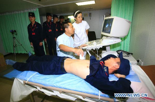 A medic provides medical service for Chinese soldiers aboard Chinese navy hospital ship Peace Ark in Gulf of Aden, Sept. 17, 2010.[Zha Chunming/Xinhua]