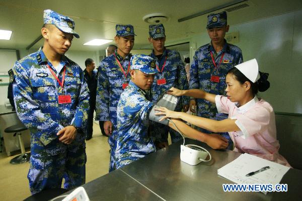  A medic provides medical service for Chinese soldiers aboard Chinese navy hospital ship Peace Ark in Gulf of Aden, Sept. 17, 2010.[Zha Chunming/Xinhua] 