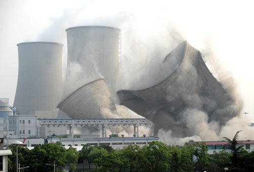 Two 90-m-high cooling towers collapse following a controlled explosion at the Huaneng Changxing Power Plant in Changxing county, Zhejiang province, on Thursday. The plant shut down two outdated electric generating sets in order to reduce coal consumption and waste emission in August. 