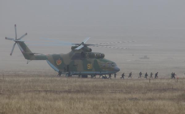 Soldiers come out from a Mi-26 helicopter at an exercise of 'Peace Mission 2010' joint anti-terror drills conducted by five Shanghai Cooperation Organization (SCO) member states in Matybulak Range of Kazakhstan, Sept. 18, 2010. Troops from five SCO countries launched the first live firing drill Friday in the southern Kazakh training ground. [Wang Jianmin/Xinhua] 