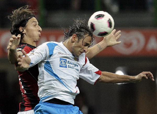 AC Milan's Zlatana Ibrahimovic (L) fights for the ball with Catania's Ciro Capuano during their Italian Serie A soccer match at the San Siro stadium in Milan September 18, 2010. (Xinhua/Reuters Photo)