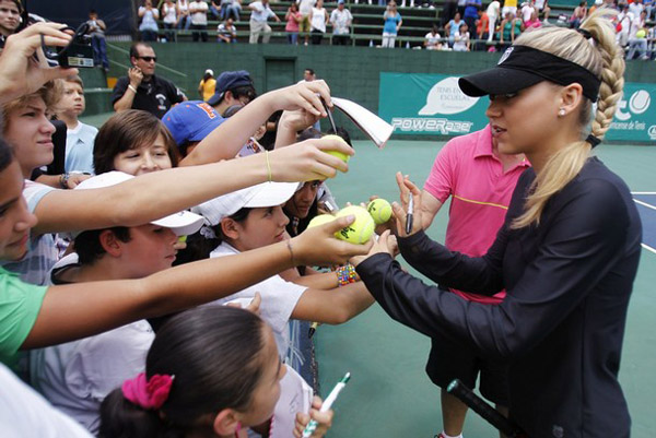 Former Russian tennis player Anna Kournikova signs autographs at a meeting with children during part of the Andre Agassi Farewell Tour in Heredia, near San Jose September 18, 2010. (Xinhua/Reuters Photo)