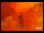 A worker walks along a street enveloped in yellow and red smoke in Jinhua city in east China's Zhejiang Province on Friday, September 17, 2010. Dark red and yellow toxic fumes blanketed streets in Jinhua city in east China's Zhejiang Province on Friday after eight tons of highly corrosive acid leaked from an abandoned chemical plant, Xinhua News Agency reports.[Photo: Xinhua]