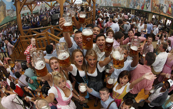 People wearing traditional Bavarian clothes together toast with beer during the opening of the 177th Oktoberfest in Munich Sept 18, 2010.[China Daily/Agencies] 