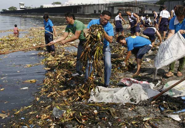 Volunteers collect waste material floating on the water during a coastal clean-up drive in Manila Bay, Sept 19, 2010.[China Daily/Agencies]