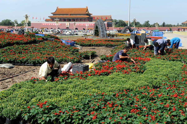 Workers decorate Tiananmen Square with flowers for the upcoming National Day that falls on Oct 1, in Beijing, Sept 19, 2010. Flowers will form the shape of a huge peony in the center of the square. [Xinhua]