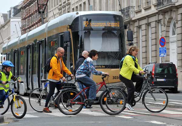 Cyclists pass by a tram in downtown Brussels, Sept 19, 2010. A car-free day activity was held in Brussels on Sunday to advocate environmental-friendly transportation and encourage people to use public transit. Private cars were forbidden on the road and public vehicles were free from 9 am to 7 pm on that day. [Xinhua]