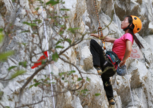 A woman competes at the Luocheng international rock climbing competition on Sept 19, 2010. [Xinhua]