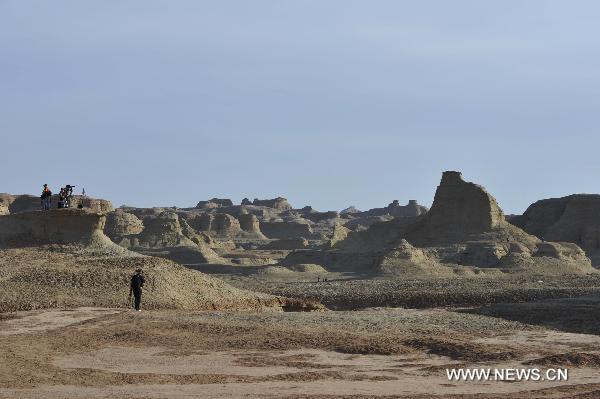 Tourists take pictures at Urho Wind City over 100km northeast of Kramay City, northwest China's Xinjiang Uyghur Autonomous Region on Sept. 19, 2010. Urho Wind City, with its unique wind-eroded geological feature, is one of the attractive scenic spots in Xinjiang. [Xinhua/Lu Peng]