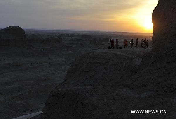 Tourists take pictures at Urho Wind City over 100km northeast of Kramay City, northwest China's Xinjiang Uyghur Autonomous Region on Sept. 19, 2010. Urho Wind City, with its unique wind-eroded geological feature, is one of the attractive scenic spots in Xinjiang. [Xinhua/Lu Peng]