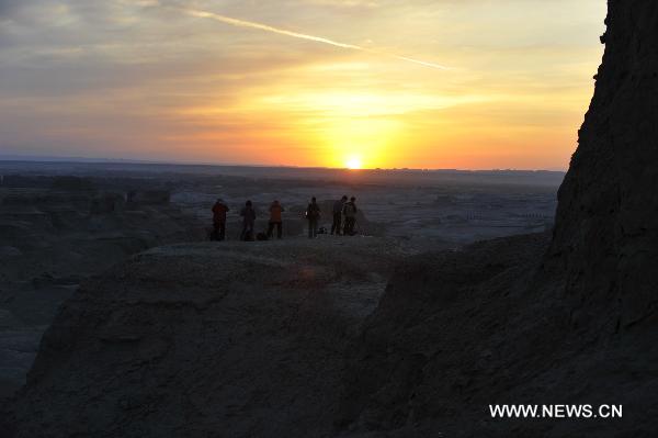 Tourists take pictures at Urho Wind City over 100km northeast of Kramay City, northwest China's Xinjiang Uyghur Autonomous Region on Sept. 19, 2010. Urho Wind City, with its unique wind-eroded geological feature, is one of the attractive scenic spots in Xinjiang. [Xinhua/Lu Peng]