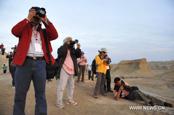 Tourists take pictures at Urho Wind City over 100km northeast of Kramay City, northwest China's Xinjiang Uyghur Autonomous Region on Sept. 19, 2010. Urho Wind City, with its unique wind-eroded geological feature, is one of the attractive scenic spots in Xinjiang. [Xinhua/Lu Peng]