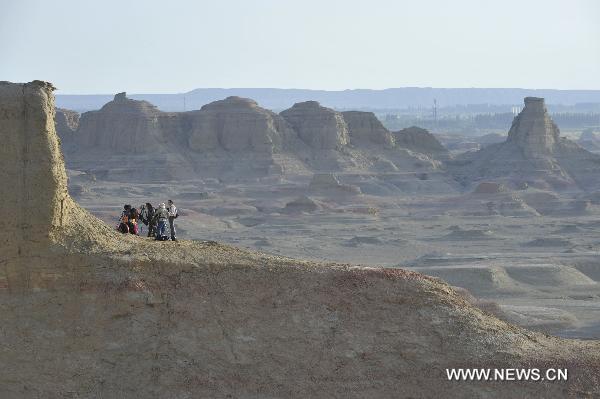 Tourists take pictures at Urho Wind City over 100km northeast of Kramay City, northwest China's Xinjiang Uyghur Autonomous Region on Sept. 19, 2010. Urho Wind City, with its unique wind-eroded geological feature, is one of the attractive scenic spots in Xinjiang. [Xinhua/Lu Peng]