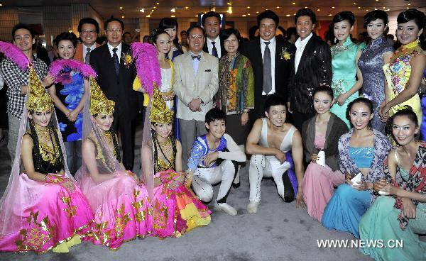 Hong Kong Chief Executive Donald Tsang (C) and his wife pose for photos with performers during an evening gala celebrating the upcoming mid-autumn day in Hong Kong, south China, Sept. 19, 2010.