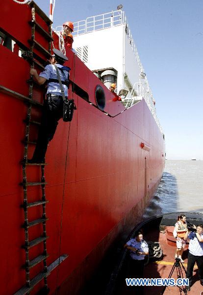 A frontier policeman goes aboard the China&apos;s icebreaker &apos;Xuelong,&apos; or &apos;Snow Dragon,&apos; for inspection in Shanghai, east China, Sept. 19, 2010.