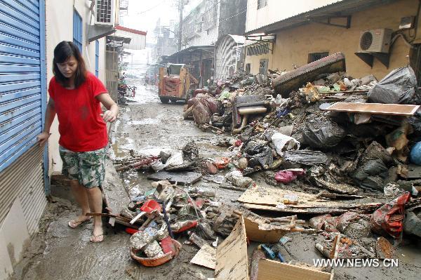 A woman walks on a flooded street in Kaohsiung County, southeast China&apos;s Taiwan, Sept. 20, 2010. Typhoon Fanapi brought heavy rains and gales to southern Taiwan after it made landfall on Sunday, causing waterlog in some regions. A total of 12,000 residents have been evacuated. [Xinhua]