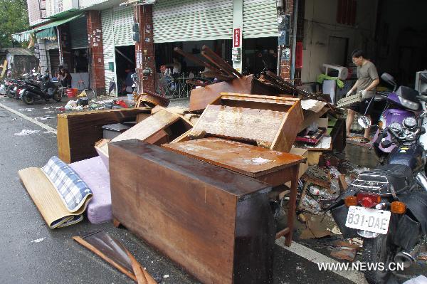 Local residents clean furnitures and articles marinated in floods in Kaohsiung County, south China&apos;s Taiwan, Sept. 20, 2010. Typhoon Fanapi brought heavy rains and gales to southern Taiwan after it made landfall on Sunday, causing waterlog in some regions. A total of 12,000 residents have been evacuated. [Xinhua]