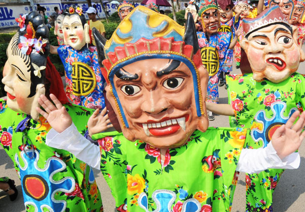 Performers with Nuo masks dance on a street in Laibin, South China&apos;s Guangxi Zhuang autonomous region on Monday. The Nuo masks represent gods worshiped by ancient Chinese people and they are said to protect the people and bring prosperity. [Xinhua]