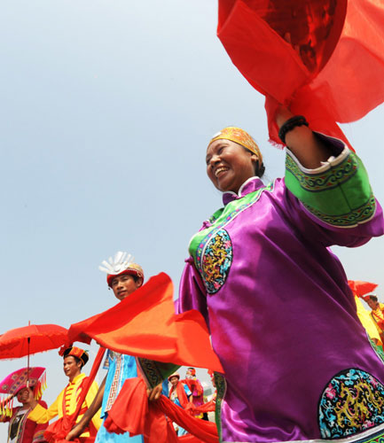 A traditional marriage ritual of the Zhuang ethnic group is performed, where the bridegroom is walking next to the maid in purple on a street in Laibin, South China&apos;s Guangxi Zhuang autonomous region on Monday. [Xinhua]