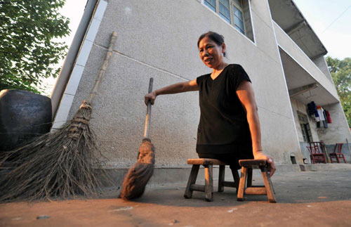 Xu sweeps the yard of her house with a broom in Xiangtan, Central China&apos;s Hunan province, Sept 15, 2010. [Xinhua] 